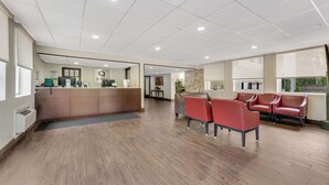 A reception area with a counter, seating, and a view of the outside. - Quality Inn Easton (Easton)