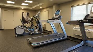 Ein Fitnessraum mit Laufbändern, Crosstrainern und einem Ergometer.