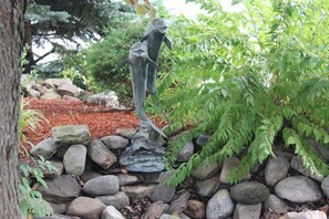 A garden with a statue of a dolphin, surrounded by rocks and greenery. - Aderi Hotel Lewisburg (Lewisburg)