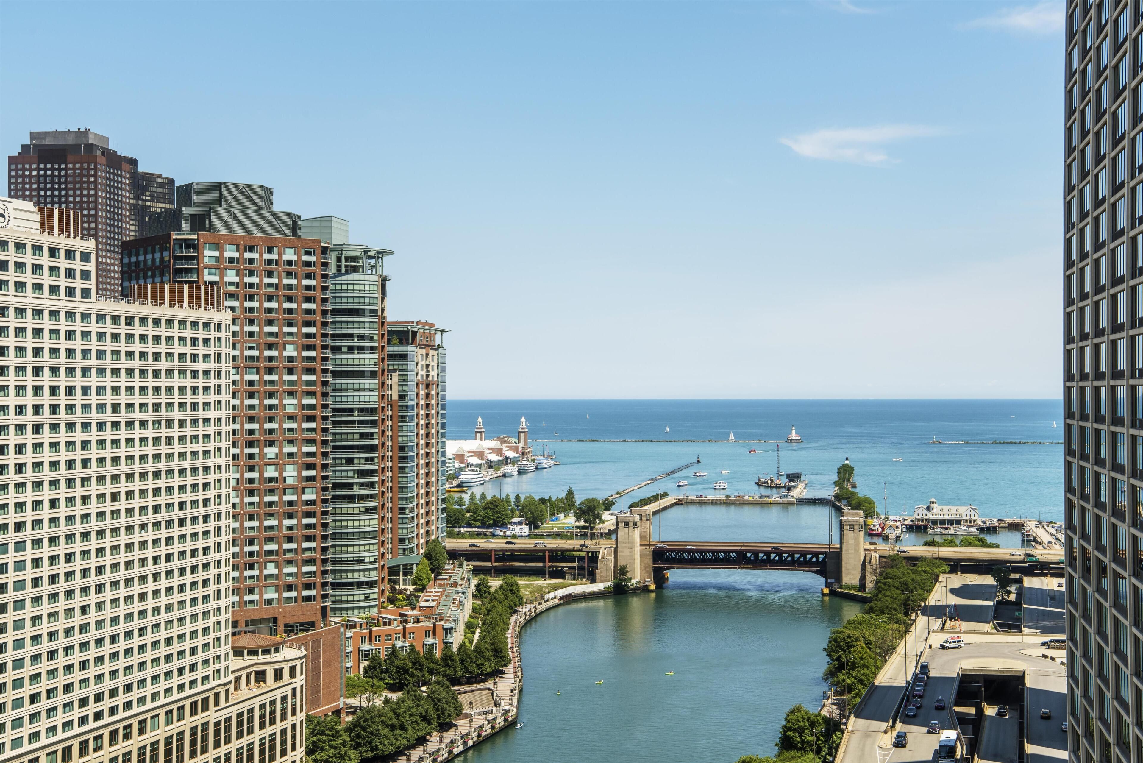 A high-rise hotel with a view of a river and marina.