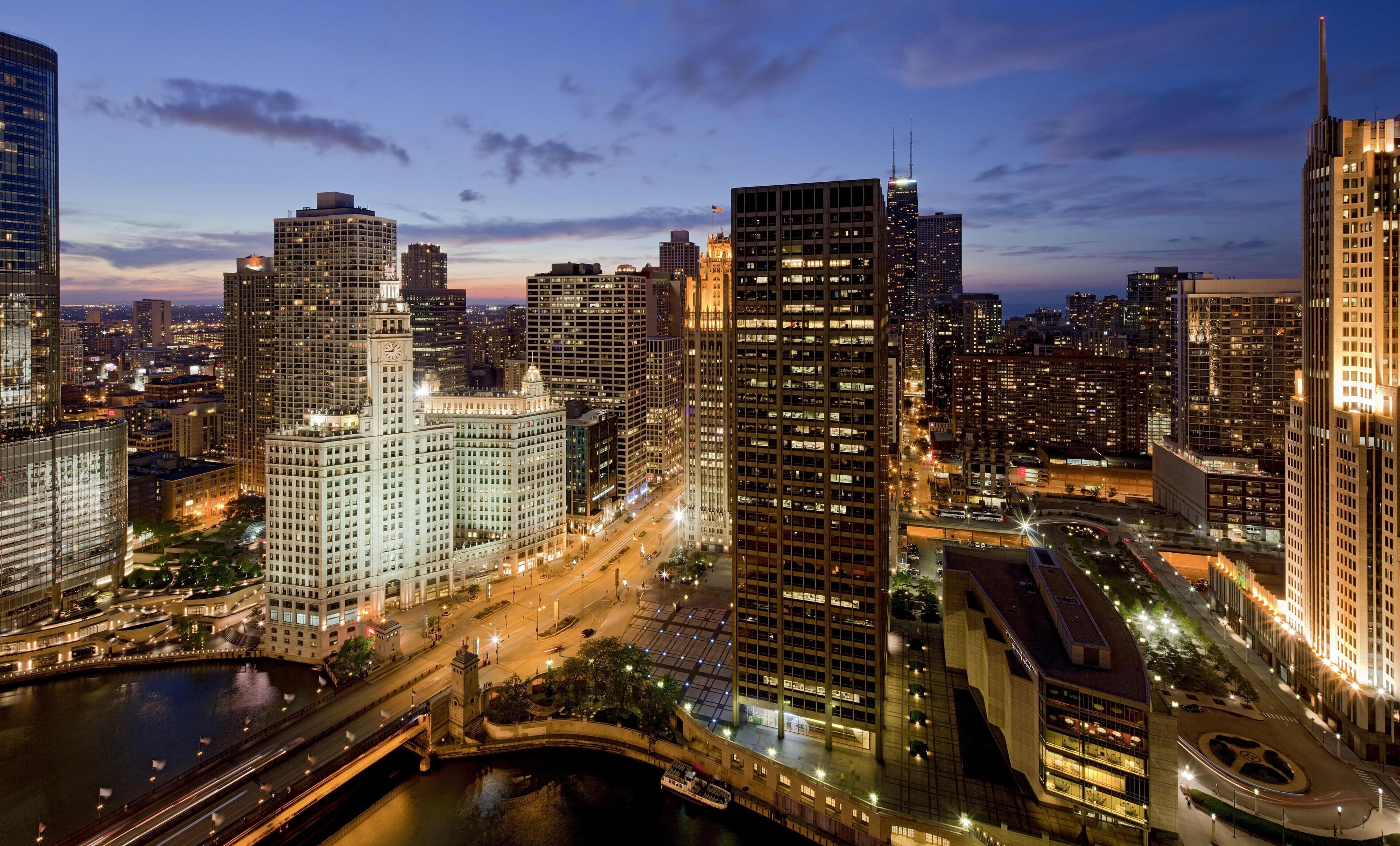 A cityscape with high-rise buildings, a river, and a bridge.