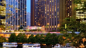 A cityscape with modern high-rise buildings, a river, and a boat.