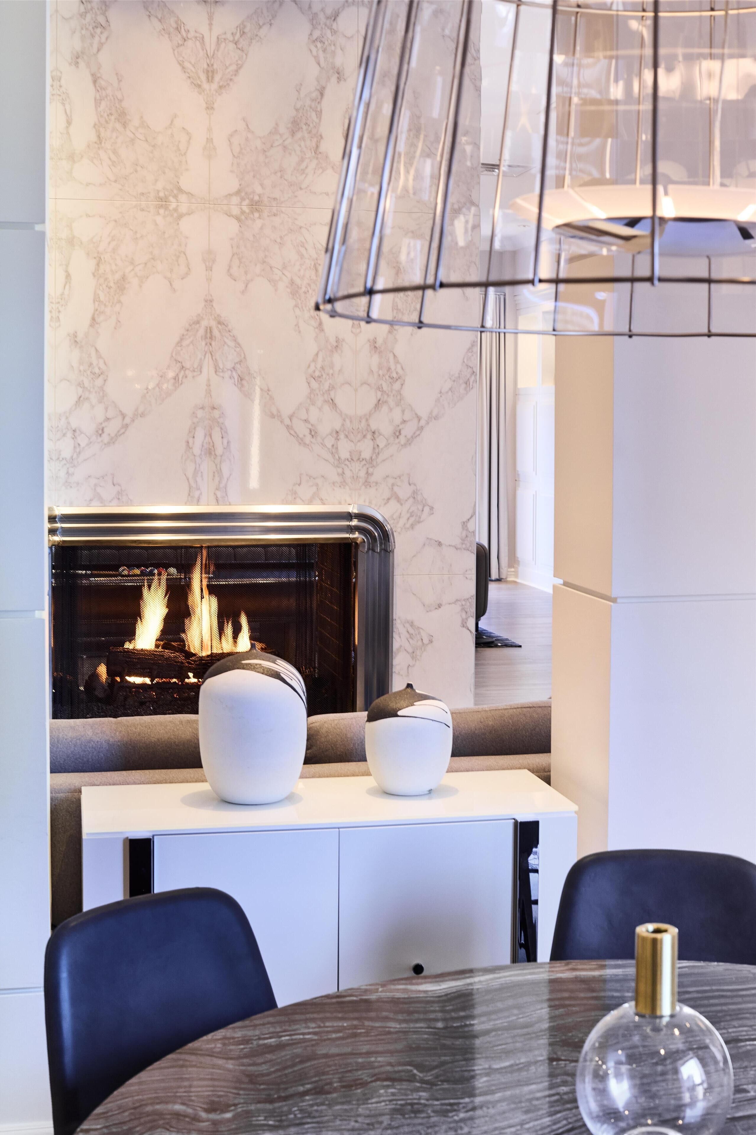 Un interior moderno con chimenea, una mesa de comedor y sillas.