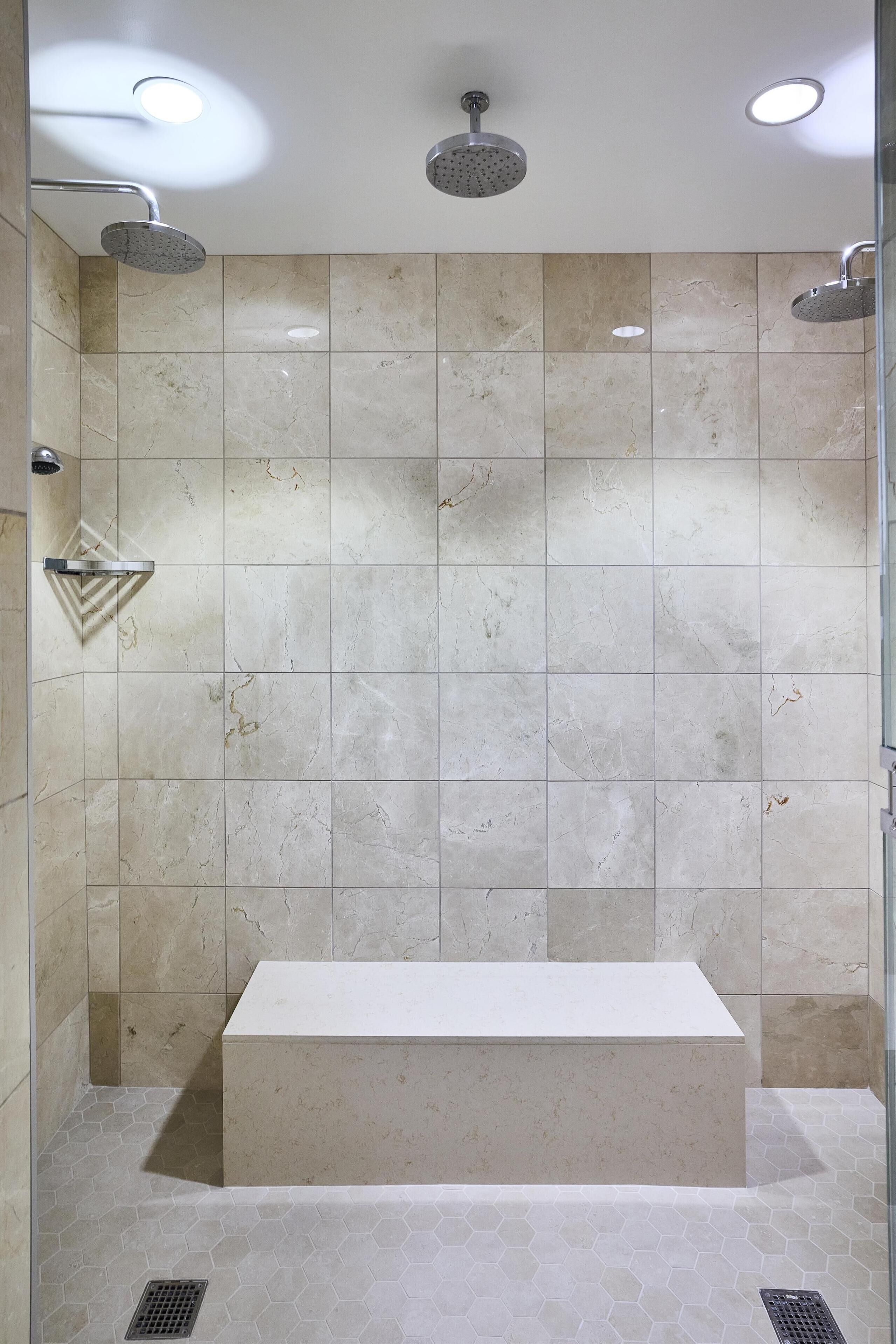 Ein modernes Badezimmer mit einer rechteckigen Badewanne, einer Duschbrause und einer Glasabtrennung.