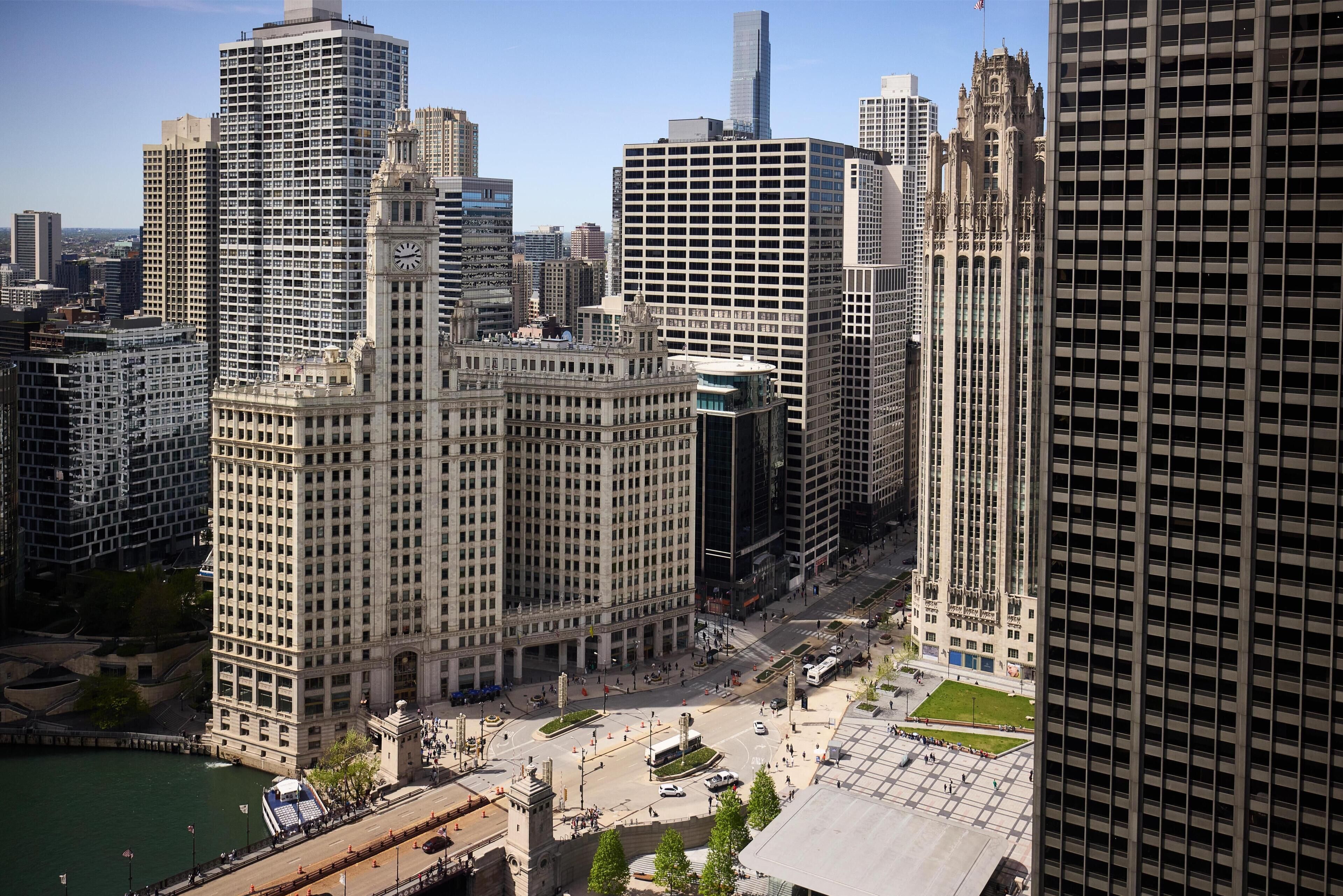A cityscape with high-rise buildings, a prominent clock tower, and a river.