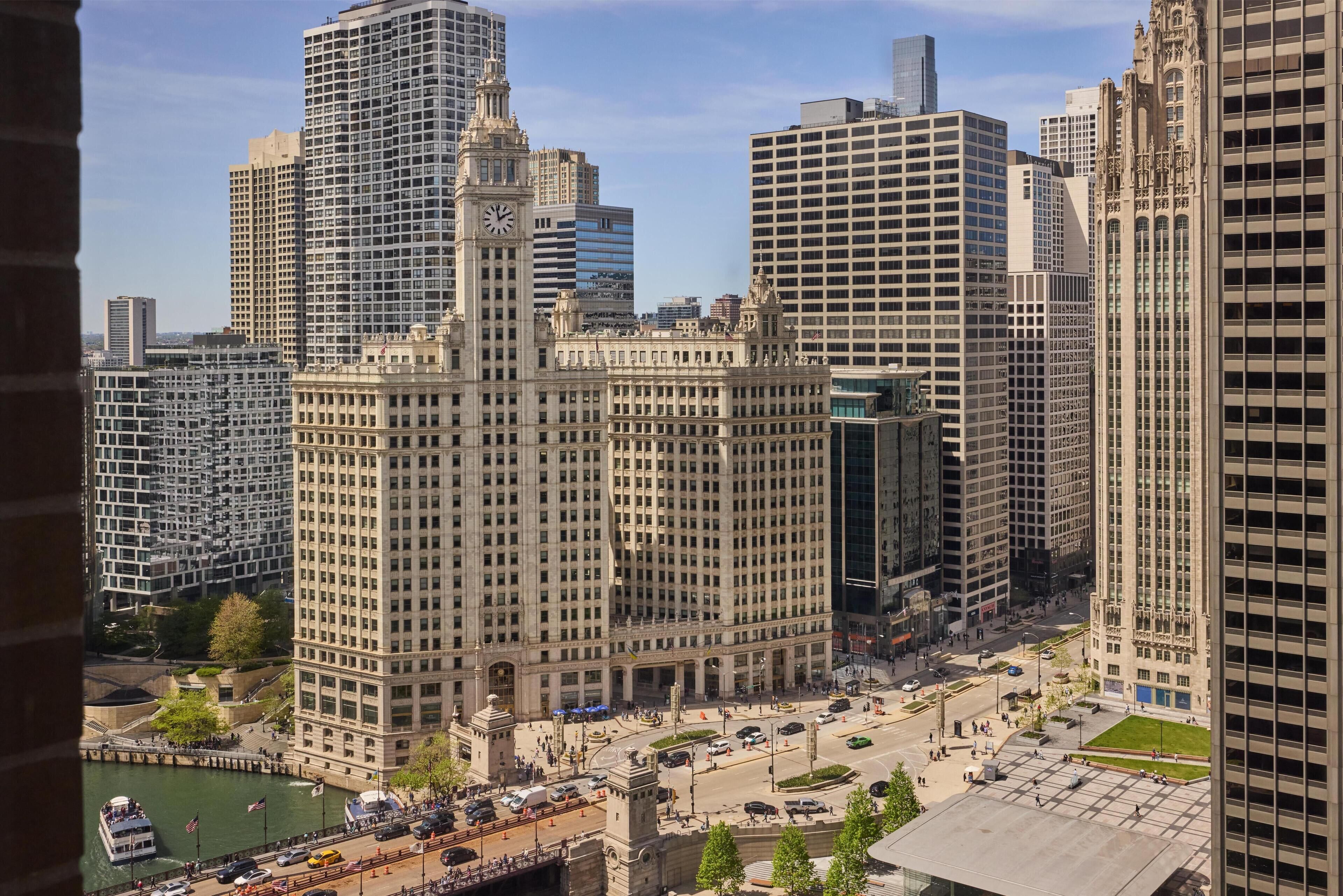 Une vue urbaine mettant en valeur un bâtiment historique remarquable, avec un beffroi, entouré d’immeubles modernes de grande hauteur.