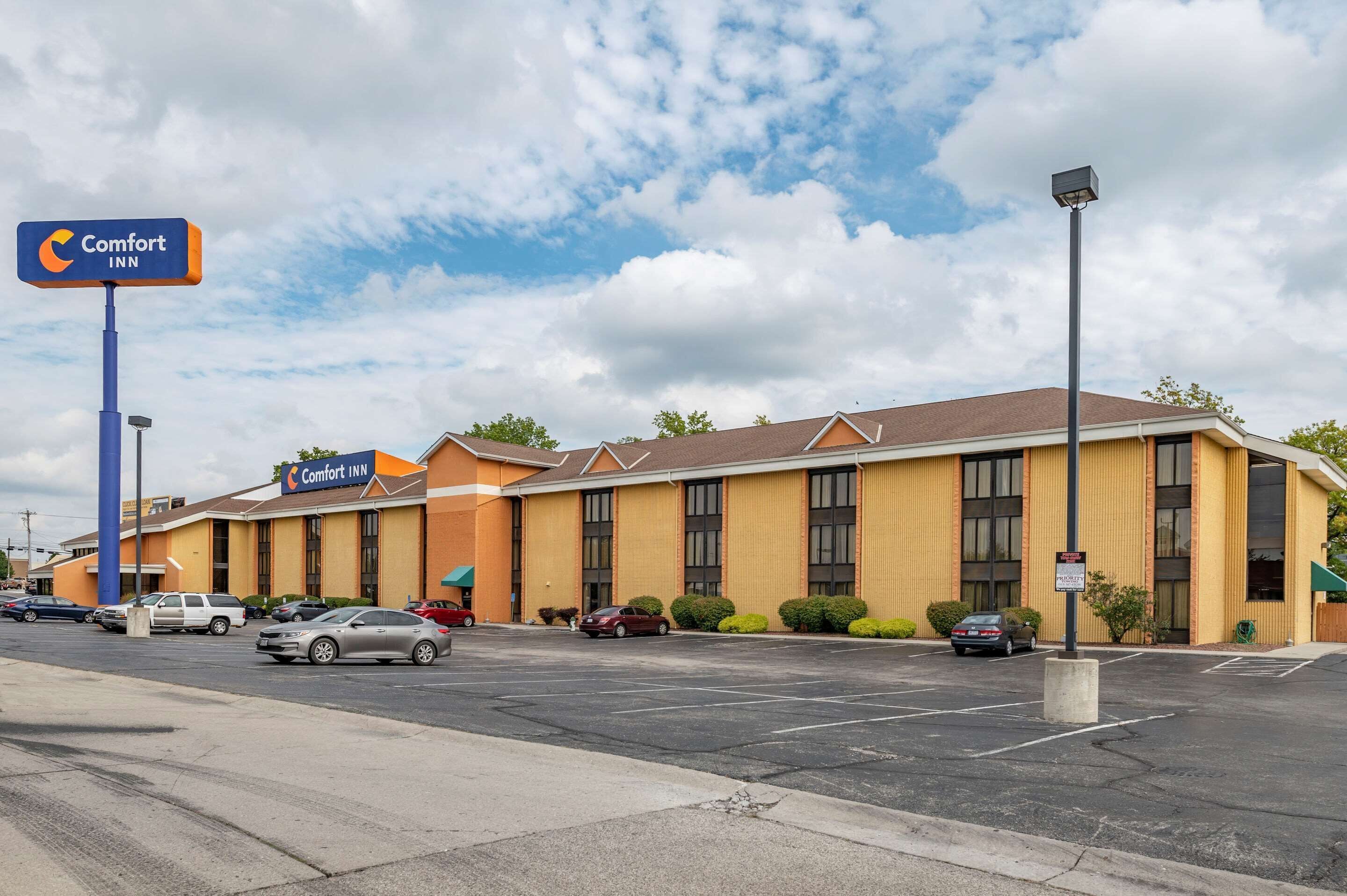 A Comfort Inn hotel with a parking lot and a clear sky.