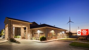 Un hotel con fachada de piedra, ventanas grandes y un cartel de Best Western PLUS Inn & Suites.