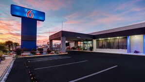 A hotel with a prominent '6' sign, a parking lot, and a modern building facade. - Motel 6 Burlington, NC (Burlington)