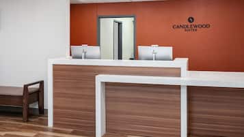 A reception desk with a mirror, two computer stations, and a bench.