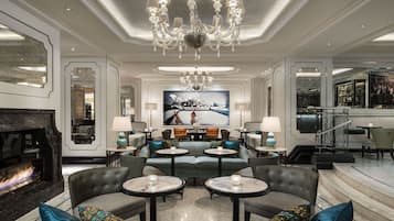 A luxurious lounge area with a fireplace, seating arrangements, and a bar.