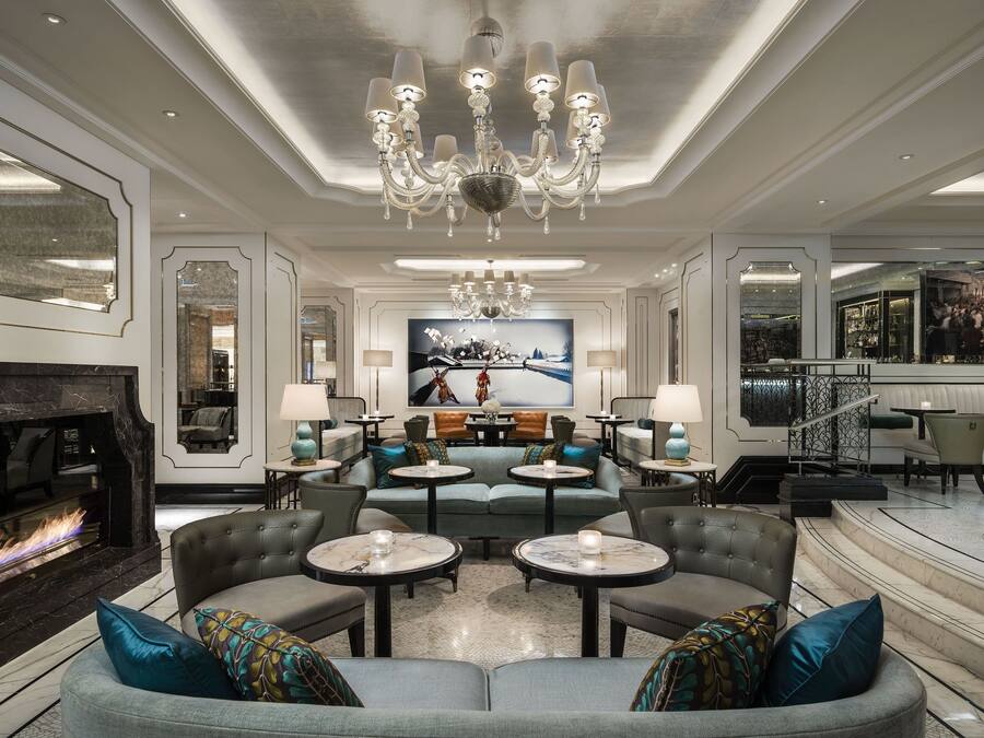 A luxurious lounge area with a fireplace, seating arrangements, and a bar.