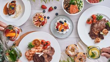A variety of dishes including grilled meat, salmon, and fruit salads, suggesting a meal setting.