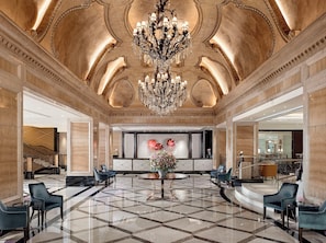 A grand lobby with a large chandelier, marble flooring, and elegant seating arrangements. - The Langham, Hong Kong (Kowloon)