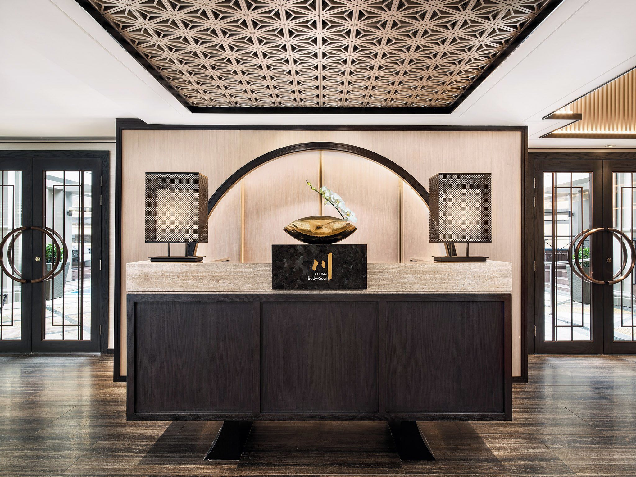 Um interior moderno com uma ilha central, dois alto-falantes laterais e um teto decorativo.