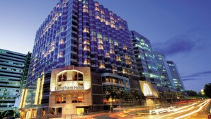 A high-rise hotel with multiple floors, a prominent entrance, and a well-lit facade.