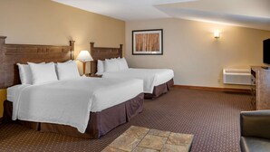 A hotel room with two beds, a desk, a chair, a TV, and a framed picture on the wall. - Best Western Desert Inn (West Yellowstone)