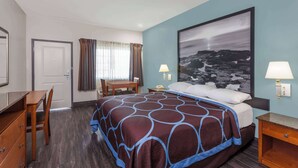 Una habitación de hotel con una cama grande, un escritorio y una silla.