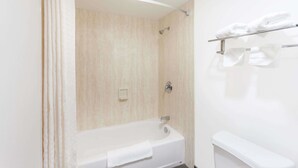 Un baño moderno con bañera, ducha y toallero.