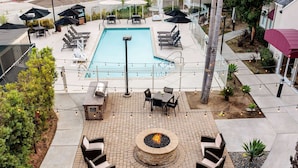 A rooftop pool area with a fire pit, lounge chairs, and umbrellas. - Sonesta ES Suites Carmel Mountain – San Diego (San Diego)
