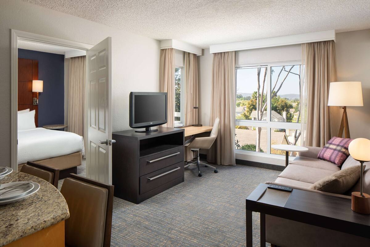Een hotelkamer met een bed, bureau, stoel en een bank.