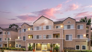 A multi-story hotel with a central entrance, balconies, and a landscaped driveway. - Sonesta ES Suites Carmel Mountain – San Diego (San Diego)