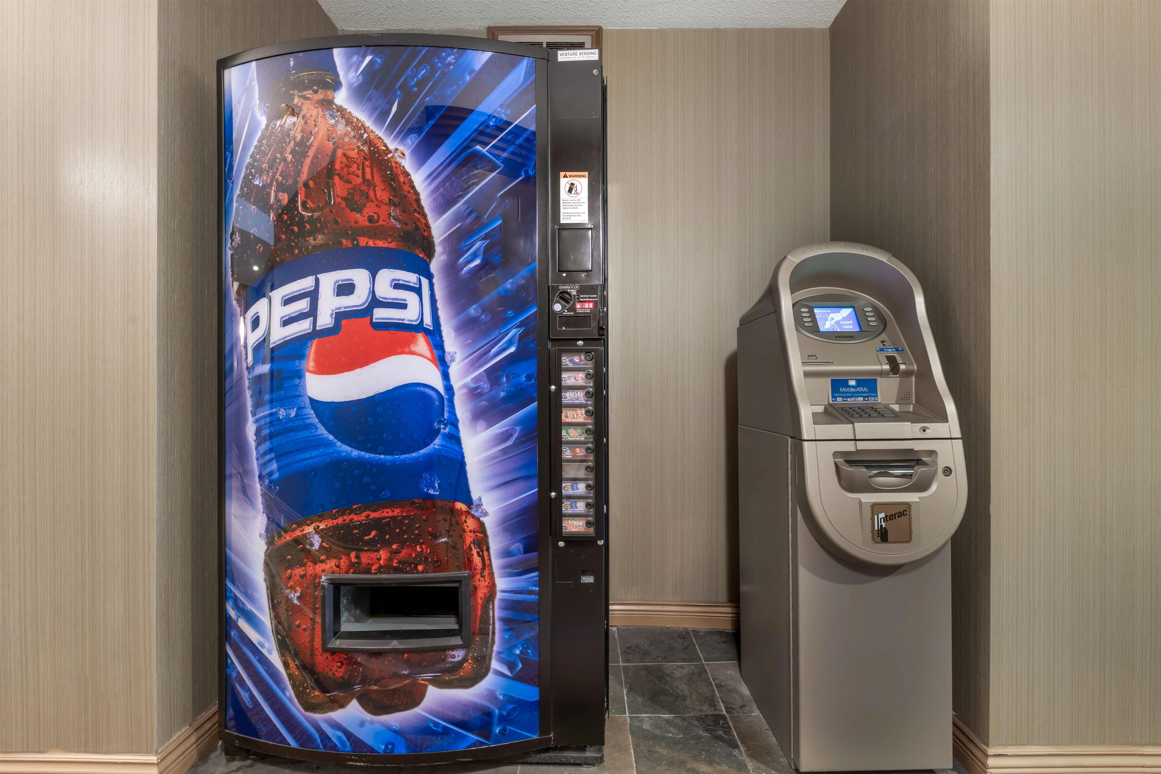 A vending machine with a Pepsi logo and a payment terminal.
