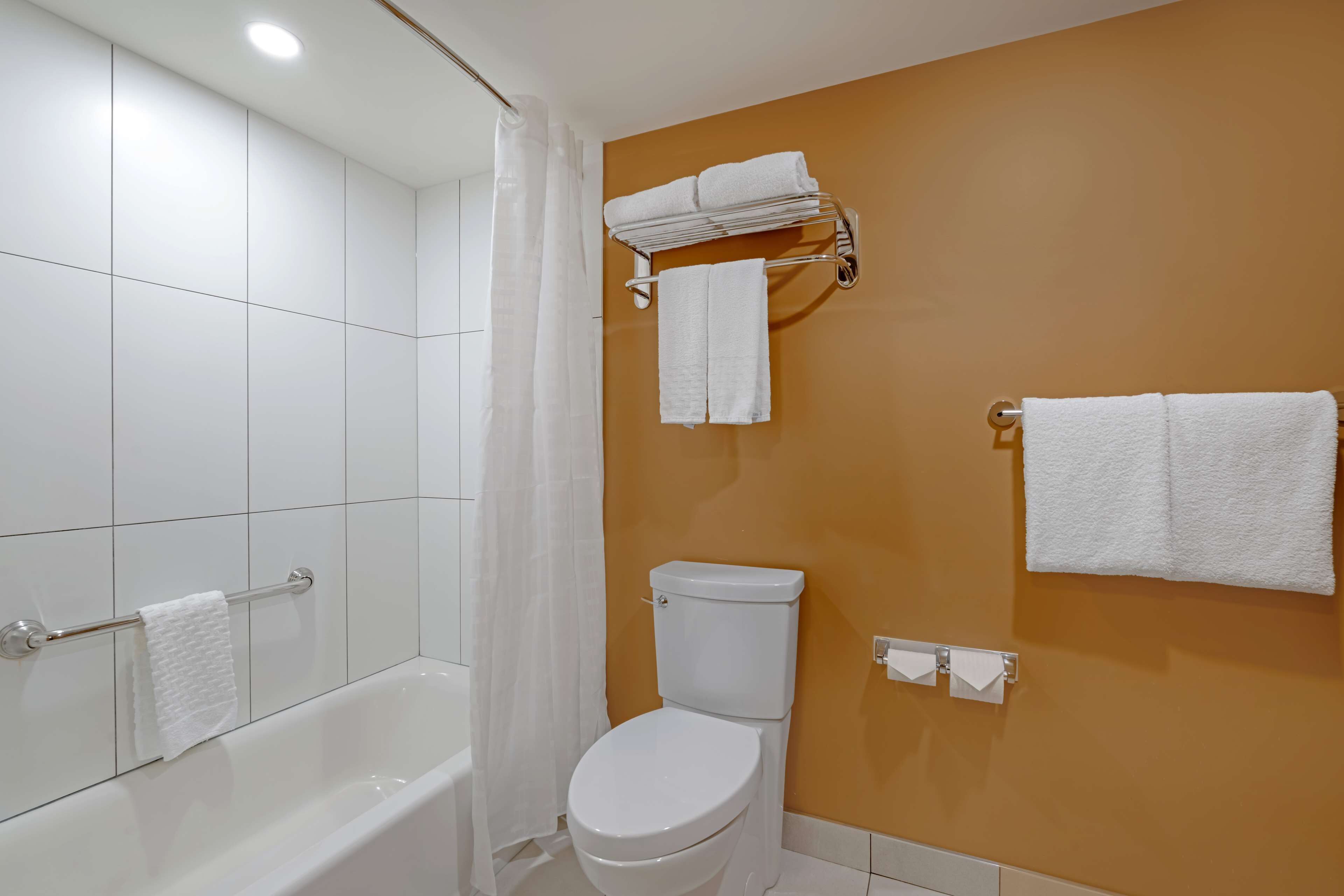 A bathroom with a bathtub, toilet, and towel rack.