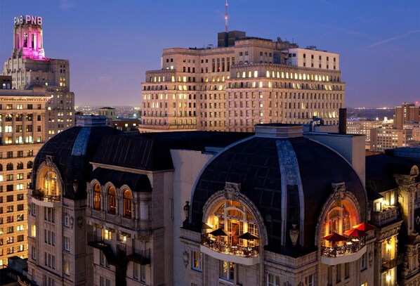 Experience the grandeur of this classic hotel, featuring domed structures and a striking tower, with spacious balconies and comfortable outdoor seating areas.