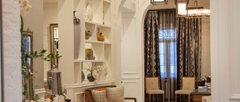 Un amplio espacio de sala con techos altos, candelabros ornamentales y una acogedora disposición de asientos.
