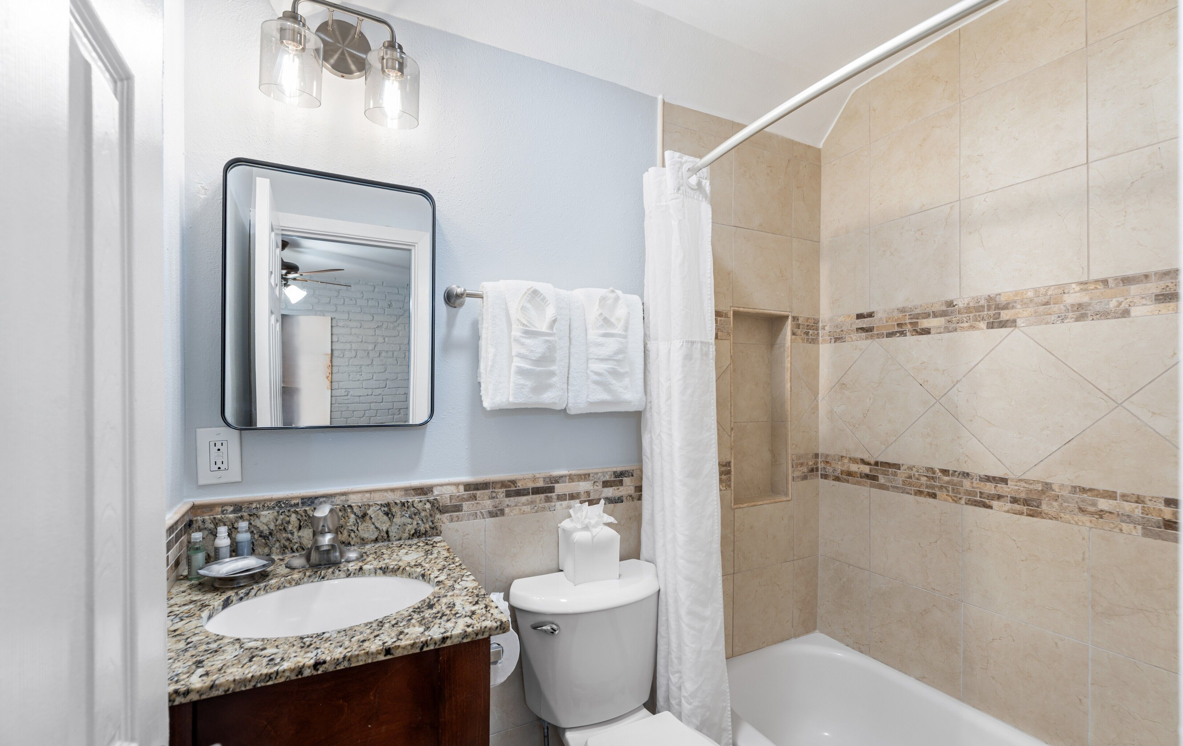 Een badkamer met wastafel, toilet en douche.