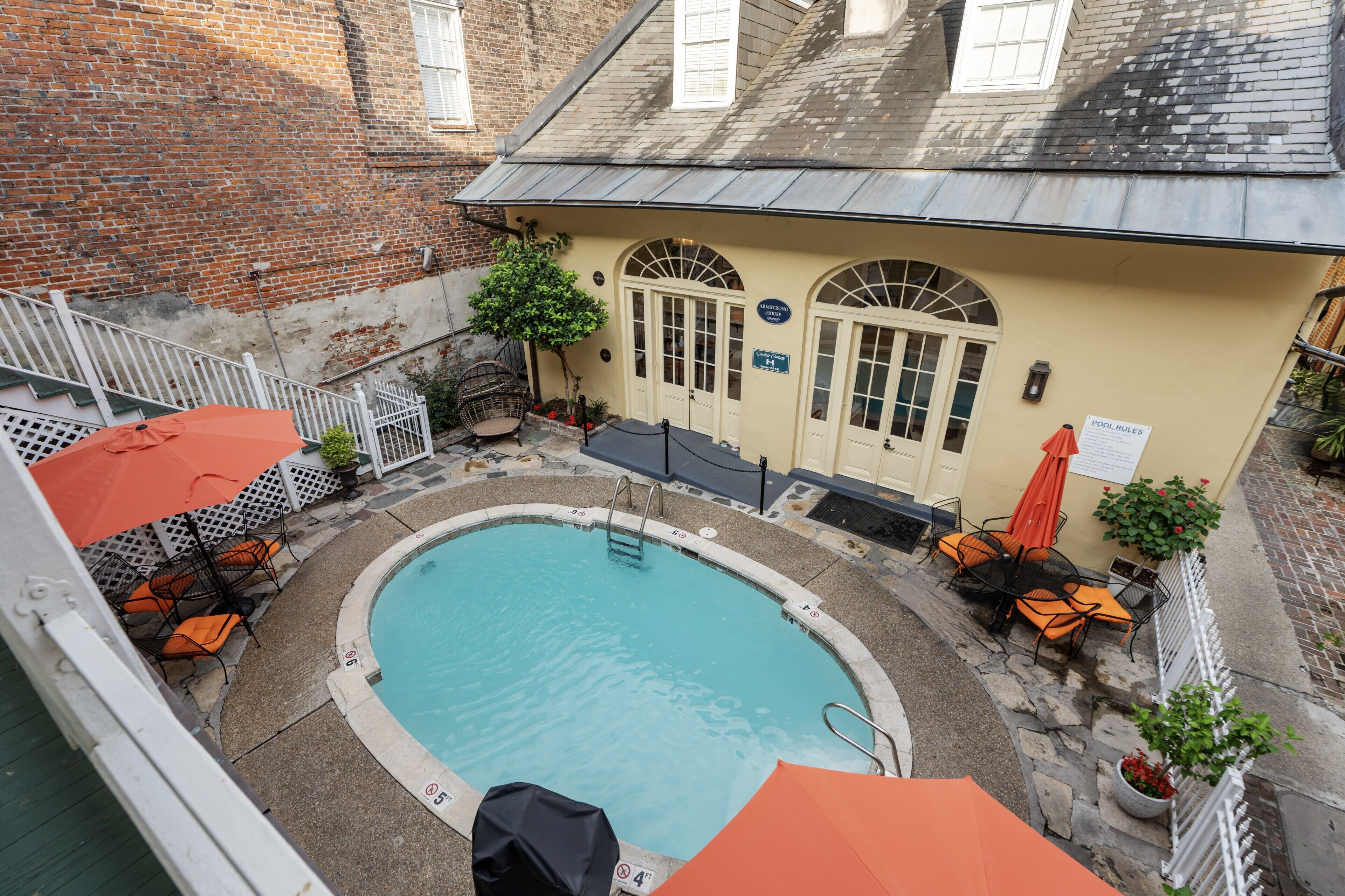 A rooftop pool area with a pool, lounge chairs, and umbrellas.