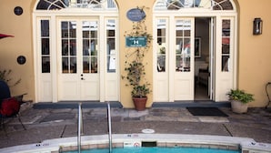 Un edificio con dos arcos de entrada, un letrero que dice "Armstrong House", y un área de piscina con una escalera metálica.