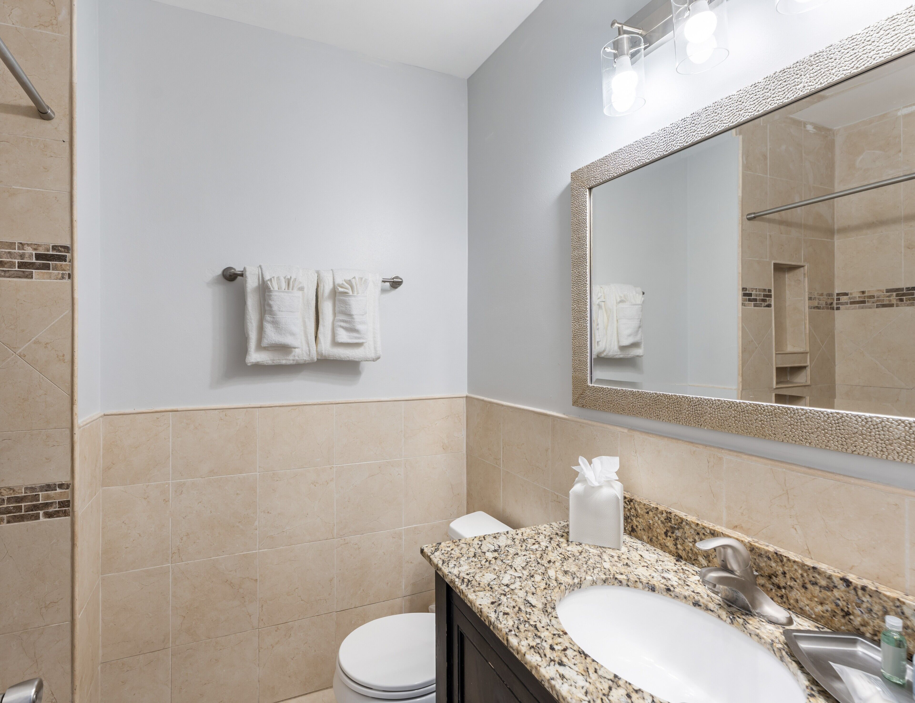 A bathroom with a sink, mirror, towel rack, and toilet.