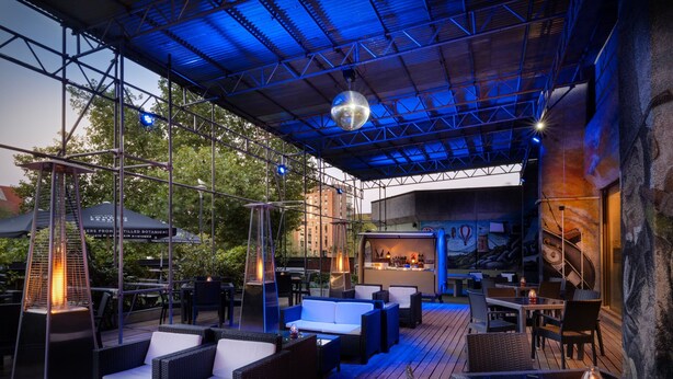 Ein Patio im Freien mit Korbmöbeln und einer Bar.