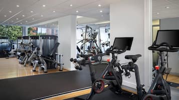 Uma academia com diversos equipamentos de exercício, incluindo bicicletas ergométricas e aparelhos de musculação.