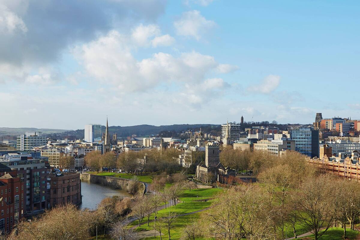 Eine Stadtansicht mit Fluss, Gebäuden und einem Park.