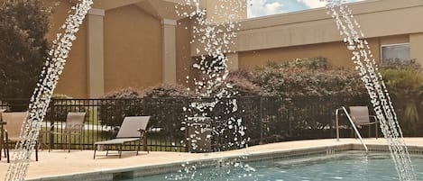 Una piscina al aire libre de temporada, sombrillas