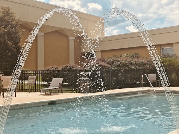 Una piscina al aire libre de temporada, sombrillas