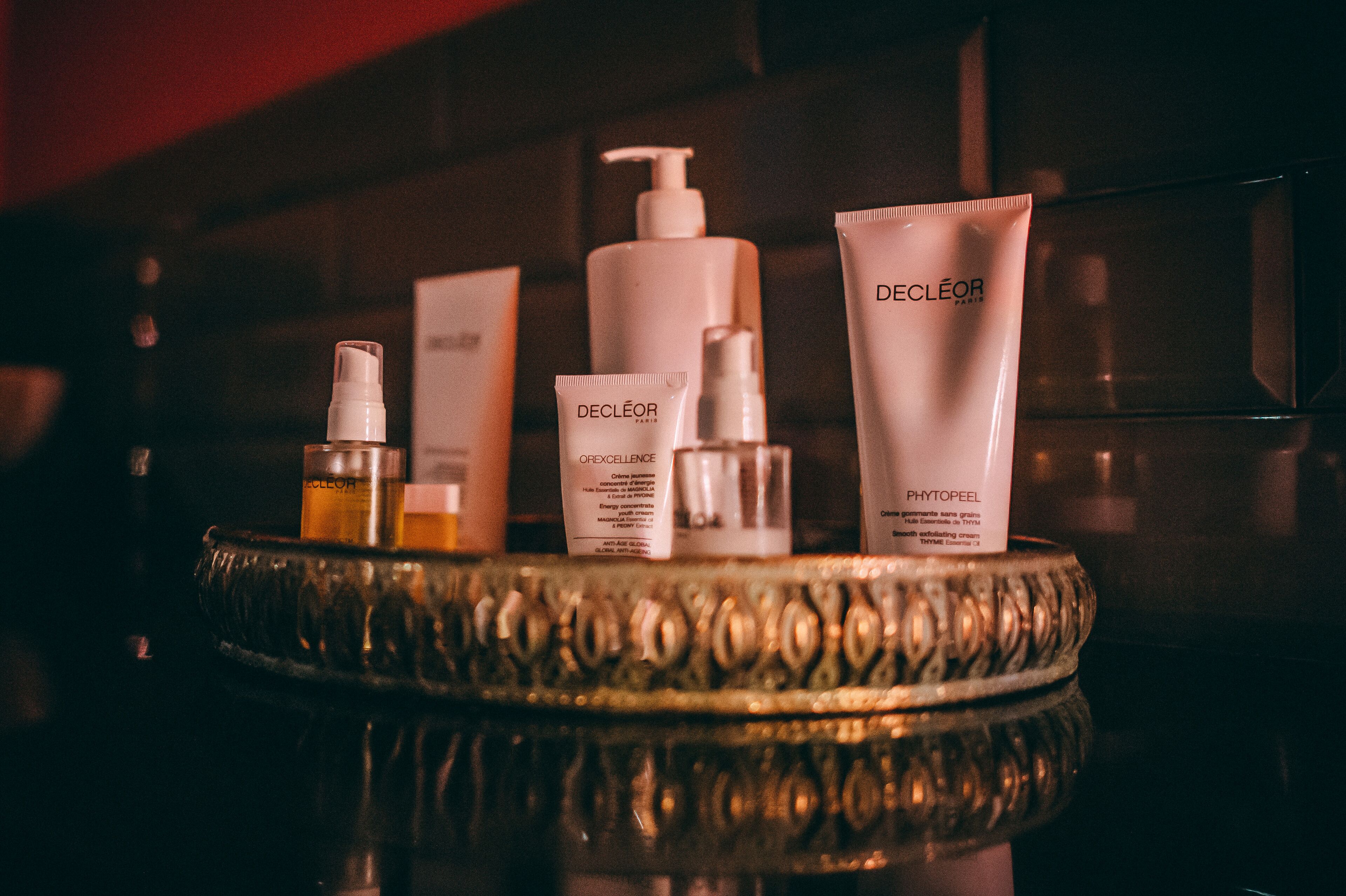 A tray with various skincare products including a pump bottle, a tube, and a tube with a pump.
