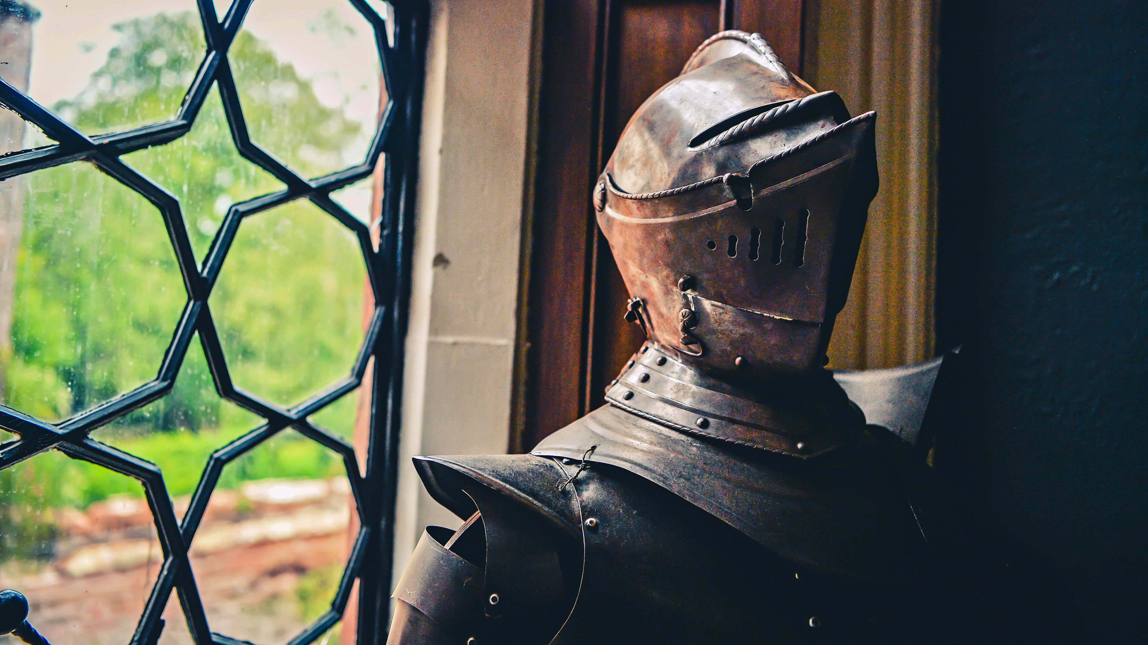 A medieval knight's helmet with a visor, mounted on a wall.
