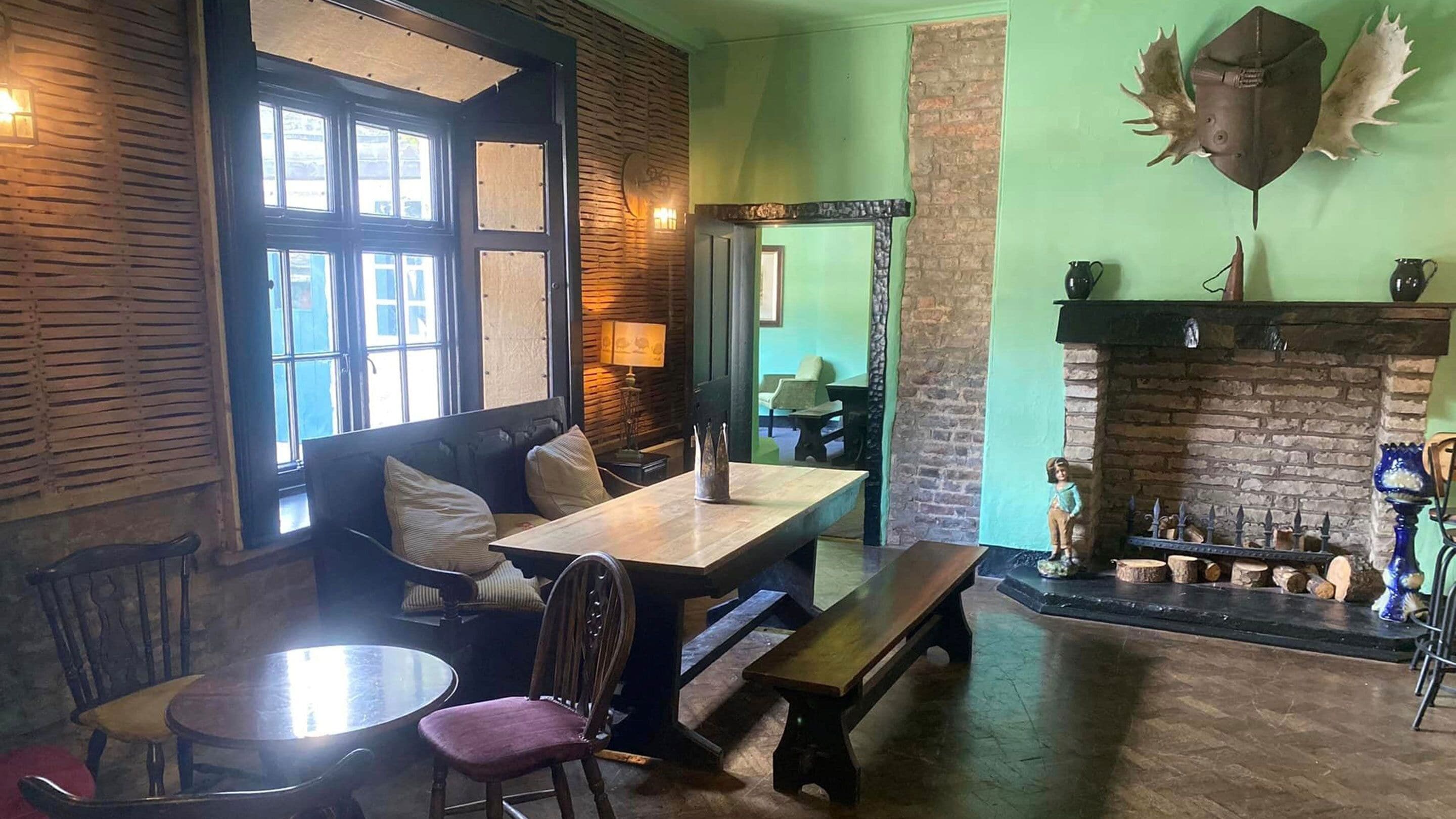 Une pièce chaleureuse avec un banc en bois, une table et une cheminée.