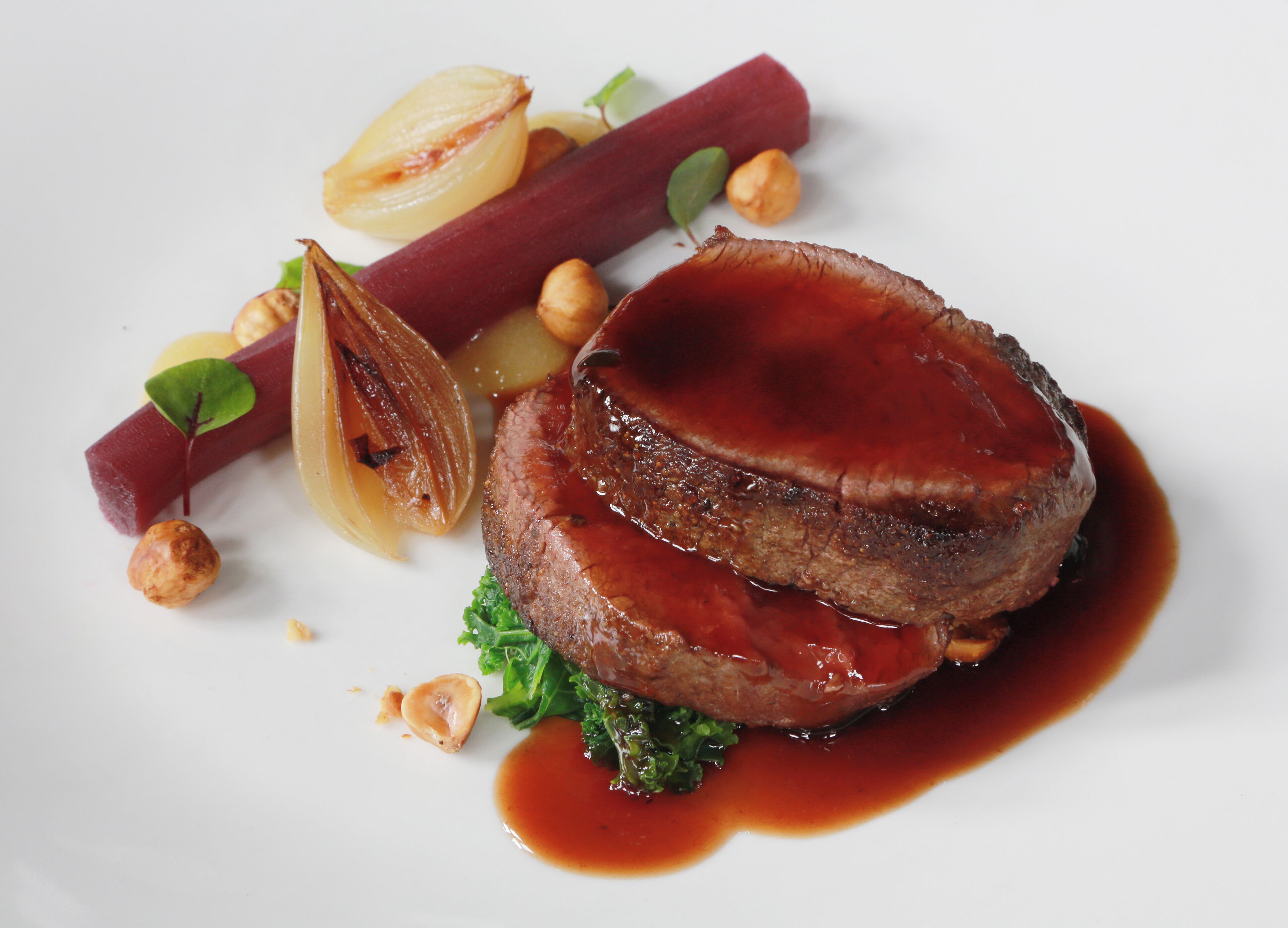 Un plato de comida con carne, verduras y salsa.