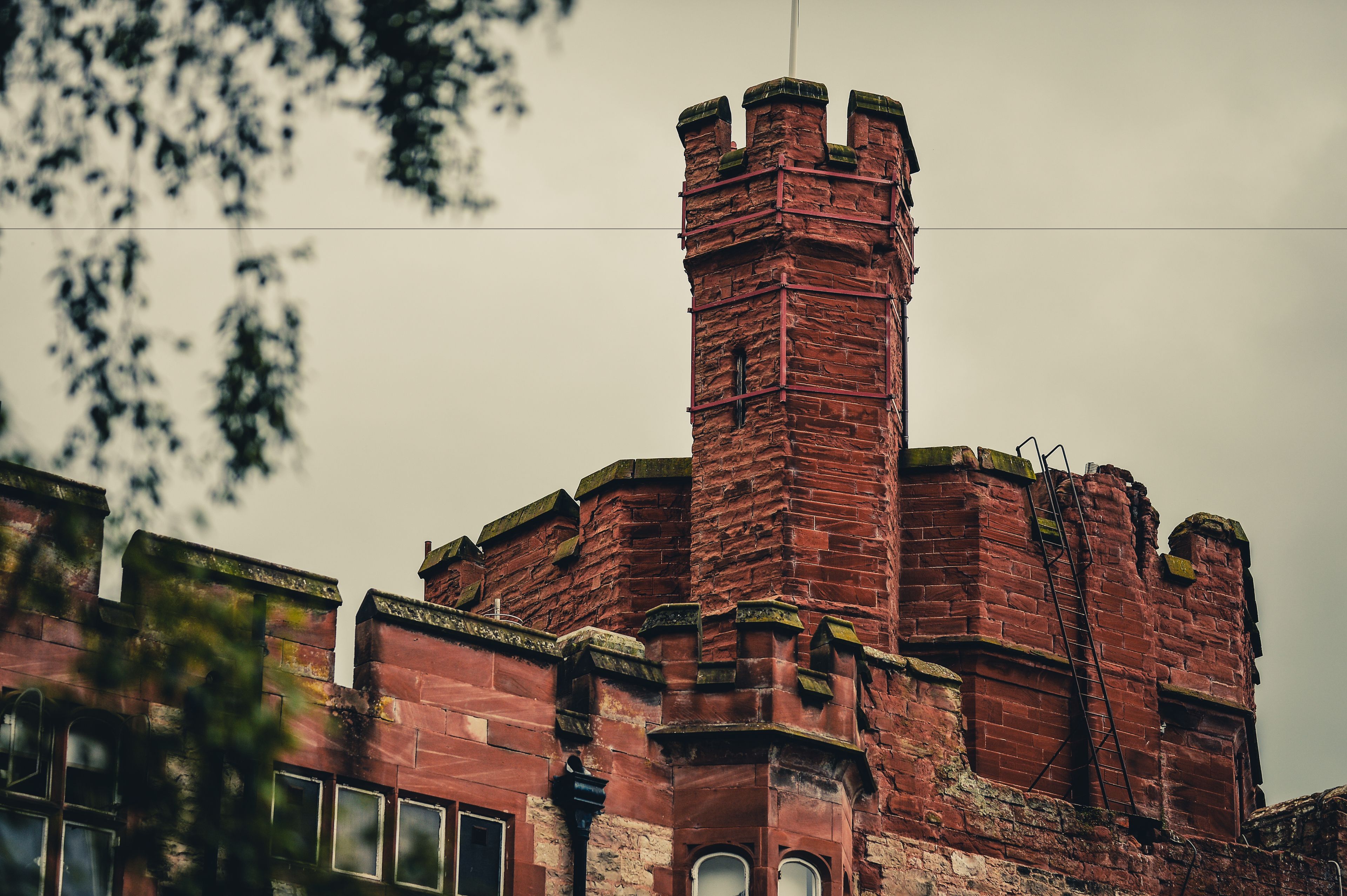 A historic brick building with a prominent tower and arched windows.
