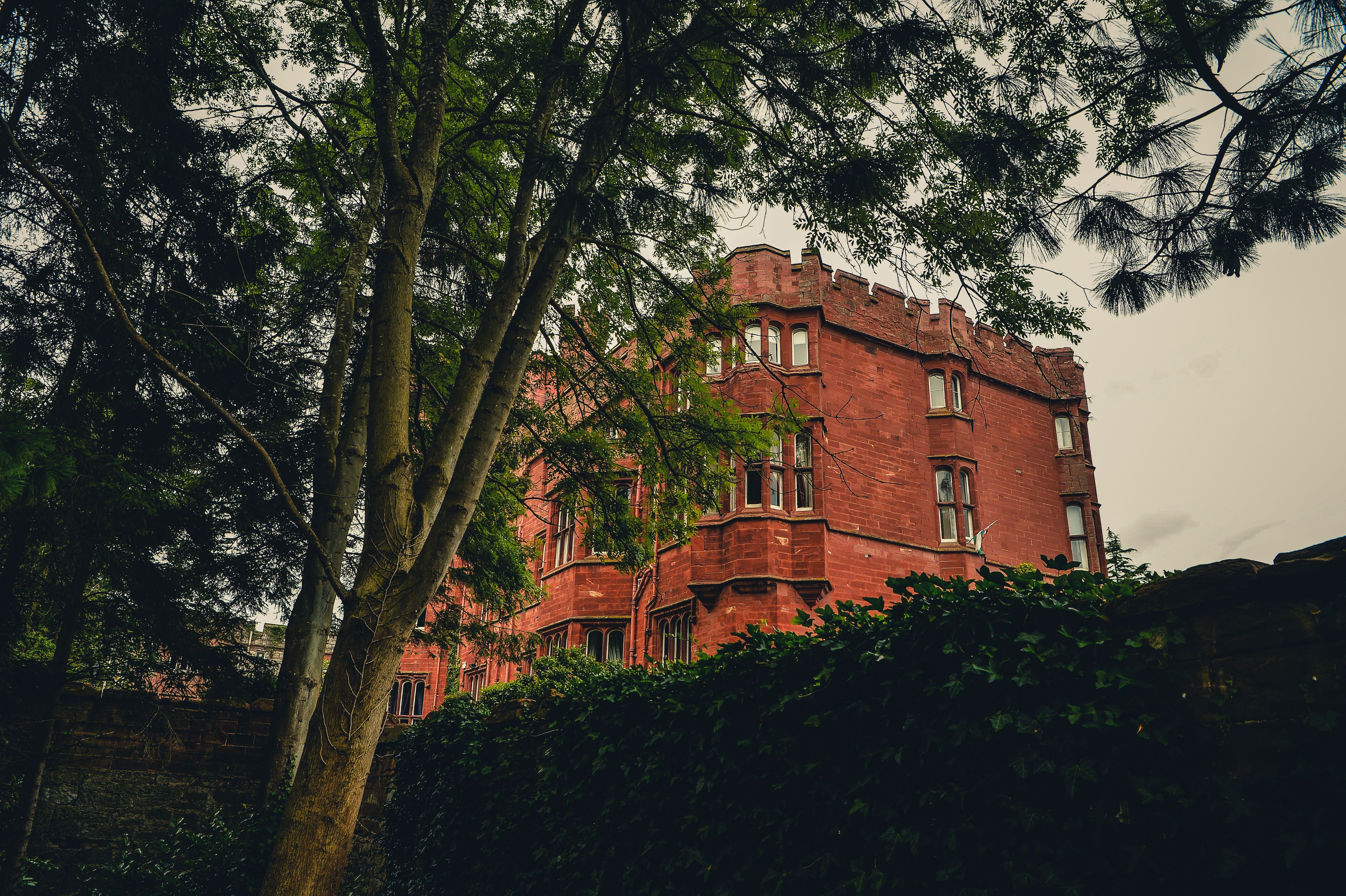 A large red brick building with multiple windows and a prominent tower.