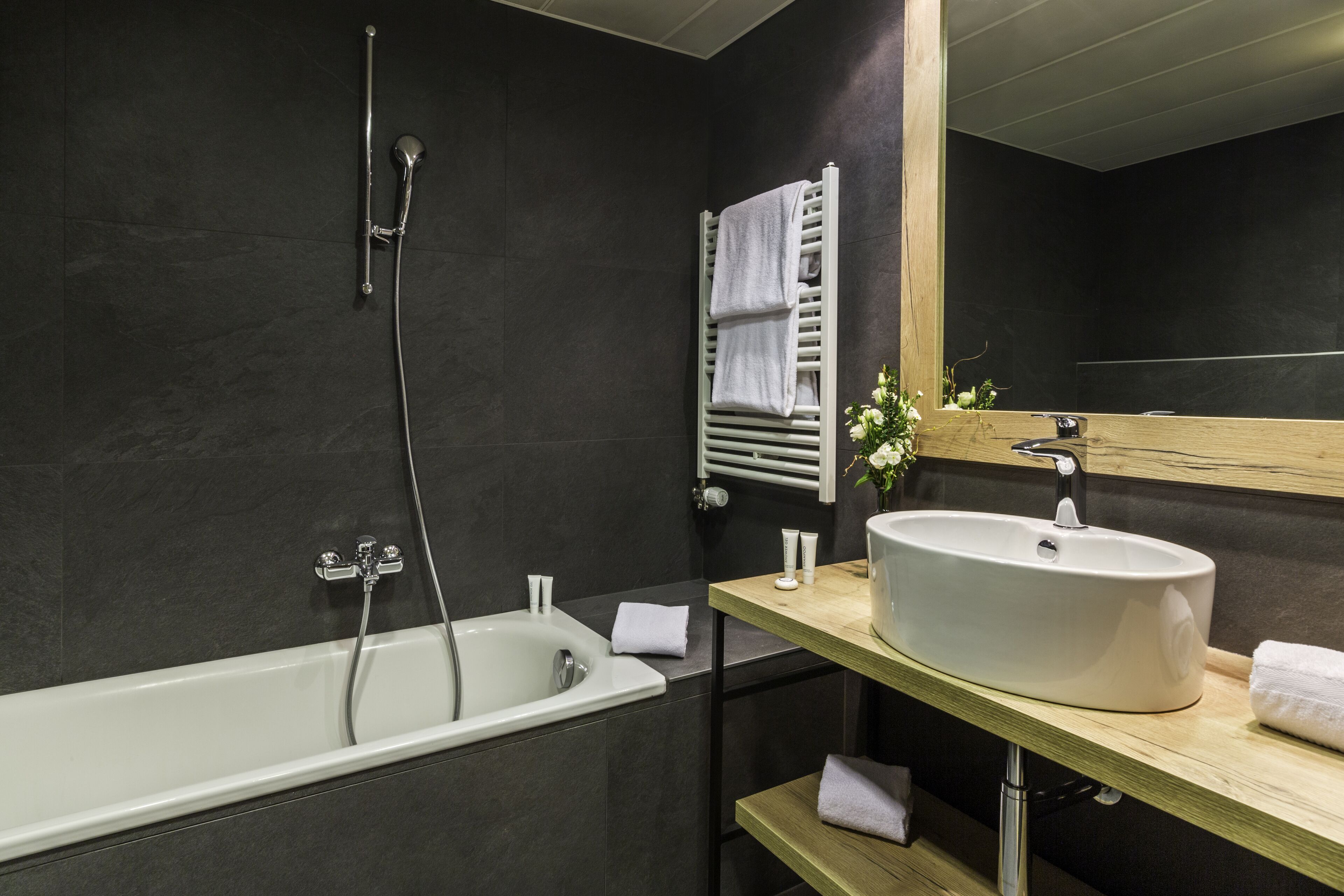 A modern bathroom with a bathtub, a sink, and a mirror.