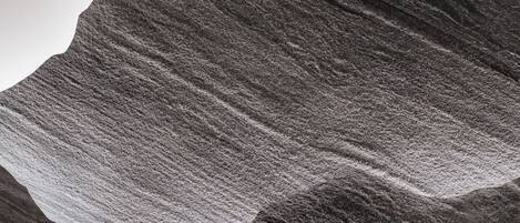 A mountain with a rugged, textured surface and a pointed peak.