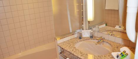 A bathroom with a bathtub, sink, and mirror.