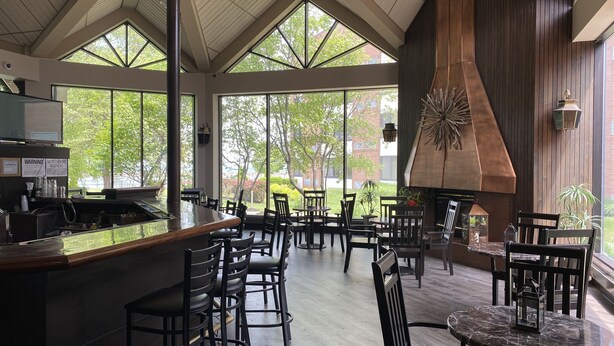 A spacious indoor area with high ceilings, large windows, and a central bar area.