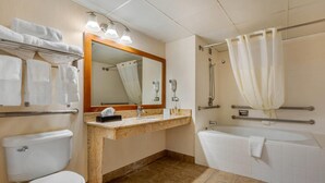 A bathroom with a toilet, sink, mirror, shower, and bathtub.